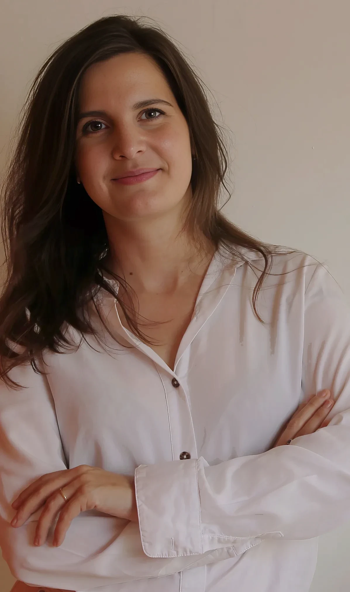 Lynn Van Mechelen, staand in een wit hemd tegen een lichte wand